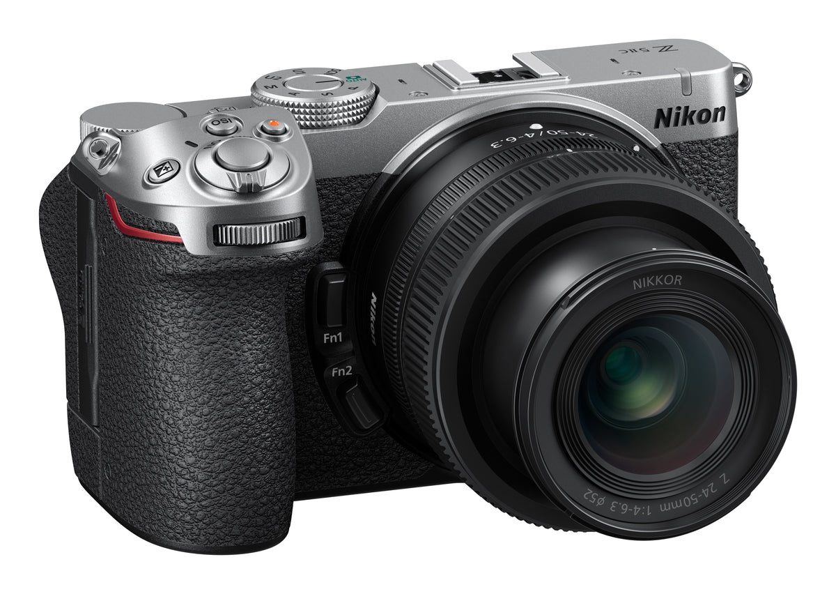 A Nikon mirrorless camera with a silver top plate, black textured grip, and attached black Nikkor lens, shown on a plain white background.