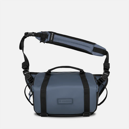 blue shoulder bag with a visible brand logo on a white background
